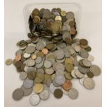 A tub containing a quantity of assorted foreign coins.