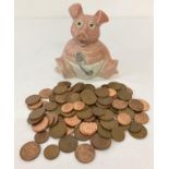 A ceramic "Woody" baby pig money box by Wade containing a quantity of British 2 and 1 pence coins.