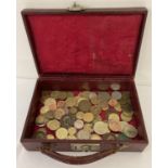 A miniature red leather case containing a collection of vintage British and world coins. British