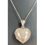 A vintage silver heart shaped locket with floral design front and back, on a 16|" fine curb chain.