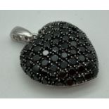 A large silver bubble heart pendant set with 74 small round cut black spinel stones. Bale has clip