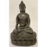 A resin figure of Buddha sitting atop a lotus flower, with green baize to underside. Approx. 19.