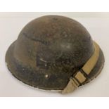 A WWII British MkII steel helmet, painted black for Home Front use. Bearing a Red Cross emblem