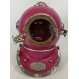 A full sized pink coloured metal Anchor Engineering divers helmet with glass panels and chrome