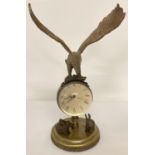 An ornamental brass ball clock with eagle shaped finial and rabbit figures to base. Wind up