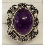 A large statement silver dress ring set with an oval amethyst cabochon stone. Marked 925 to inside