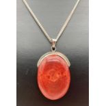 A modern design oval shaped red jasper pendant on an 18" silver curb chain with lobster clasp. Chain