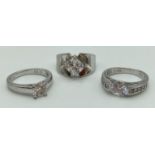 3 stone set silver solitaire style dress rings. One with central round cut clear stone, one with