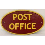 A painted cast iron oval shaped Post Office wall plaque. In red and yellow and with fixing holes.