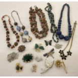 A collection of vintage and modern costume jewellery brooches and necklaces. Brooches include floral