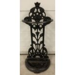 An antique cast iron umbrella/stick stand with floral decoration, painted black. Removeable base