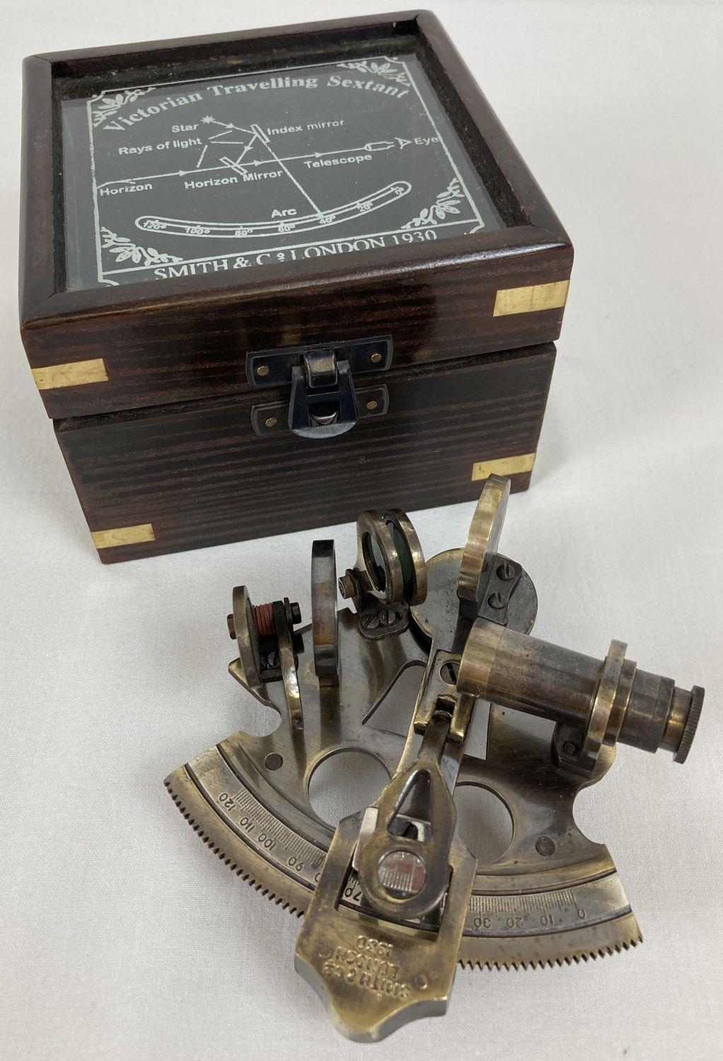 A replica wooden and glass lidded box containing a "Victorian Travelling Sextant" by Smith & Co.