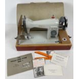 A vintage Jones electric hand sewing machine. Complete with manual, attachments, electric foot pedal