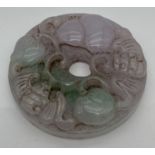 A carved lavender jade roundel with fu bat design. Approx. 5.5cm diameter.