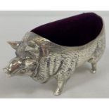 A silver pig shaped pin cushion with burgundy coloured velvet cushion. Marked '800' to underside.