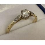 A vintage 18ct gold diamond solitaire dress ring. A central .25ct round cut diamond with 2 small