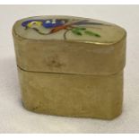 A small gilt metal pill box with shell lid and painted bird decoration. Approx. 2.3 x 2.5cm.