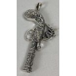 A silver whistle pendant in the shape of an ornately carved pistol. Approx. 7.5cm long (inc bale)