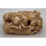 A highly carved Chinese netsuke robe toggle, in the form of a cluster of insects. Signature mark