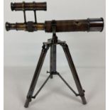 An ornamental desk top brass telescope with folding tripod stand. Telescope marked 'Kelvin & Hughes,