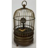 A small brass ornamental wind up birdcage clock with winding mechanism to underside. Small bird