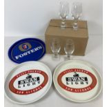 A collection of vintage brewery branded pub serving trays together with a box of 12 Stella Artois