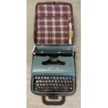 A vintage Olivetti Lettera 22 typewriter complete with original plastic cover and tartan lined carry
