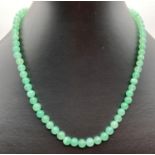 A 16 inch green jade round bead necklace with 9ct gold spring clasp.