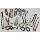 A tub of vintage and modern natural stone and glass bead costume jewellery to include necklaces,