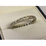 A vintage 14ct white gold full eternity ring set with clear stones. Worn mark to edge of ring. Tests