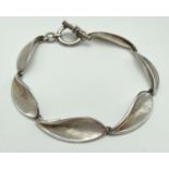 A modern design silver bracelet with leaf style links and T-bar clasp. Brushed silver detail to
