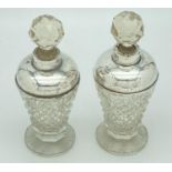 A pair of early 20th century cut glass scent bottles with silver collars and shoulders. Hallmarks