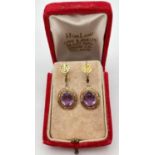A pair of vintage decorative 14ct gold, amethyst set screw back earrings with floral decoration