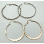 2 pairs of large silver hoop earrings. A pair of plain hoops together with a pair of twist design