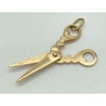 A 9ct gold charm/pendant in shape of a pair of scissors with scroll detail handles. Approx. 2.5cm