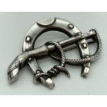 A vintage white metal horseshoe shaped brooch with rope and deer's hoof detail. Brooch clasp is