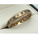A vintage 9ct gold full eternity ring set with blue and clear stones (one missing). Full hallmarks