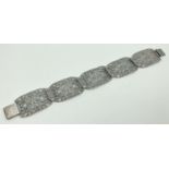 A vintage silver bracelet with 5 pierced work panels of floral decoration and push clasp. 925