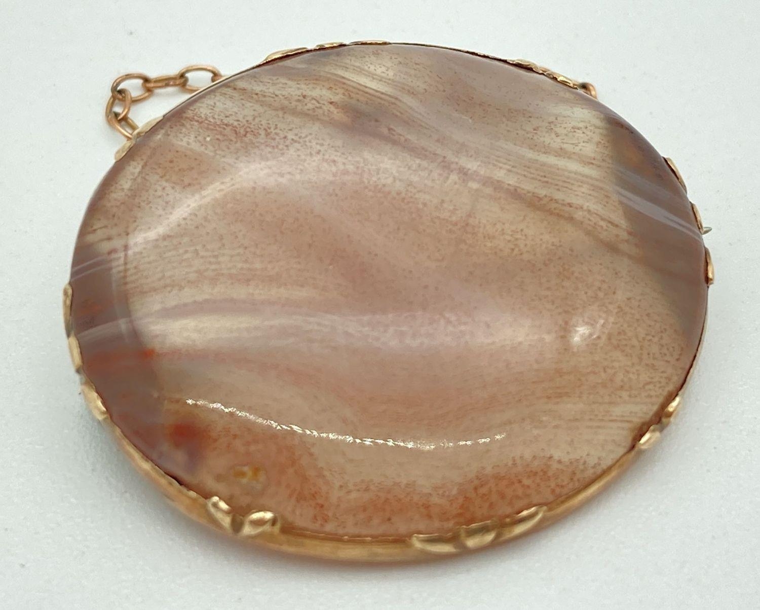 A vintage natural agate oval shaped brooch in a gold mount. Complete with safety chain. Mount