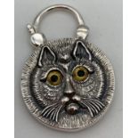 A double sided silver pendant with opening bale. Carved cats face detail to one side and round