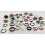 33 vintage and modern costume jewellery rings in varying designs and sizes. To include stone set,