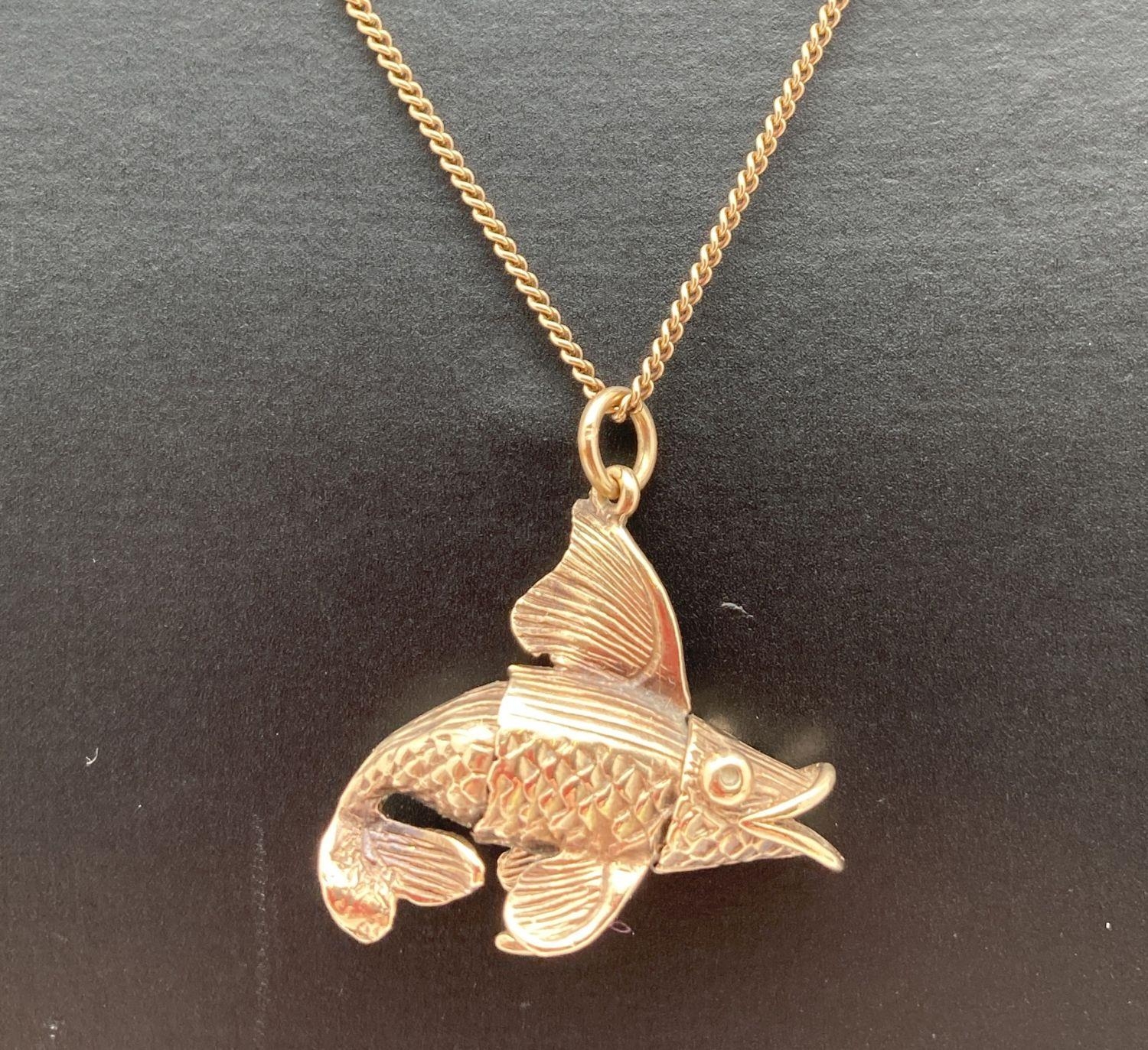 A 9ct gold fish pendant on a 9ct gold 19" fine curb chain with spring clasp. Bottom fin to fish