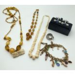 A small collection of costume jewellery to include amber glass bead necklaces, charm bracelet,