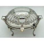 An antique silver plated, oval shaped, revolving dome toped warming dish. With decorative floral and