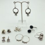 7 pairs of silver and white metal drop and stud style earrings. To include decorative hoops, faux