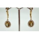 A pair of 14ct gold colour change Alexandrite drop style earrings. Each earring has a central oval