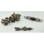 3 vintage silver and white metal brooches. An arrow sweetheart brooch with baby dragon detail, a