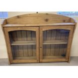 A modern pine 2 door wall hanging cabinet with interior and top shelf. Glass panelled doors,