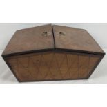 A vintage wooden casket shaped wooden work box with internal compartments and small ring style brass