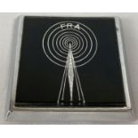 A Free Radio Association car badge with fixings. Radio tower detail with FRA above radio waves.